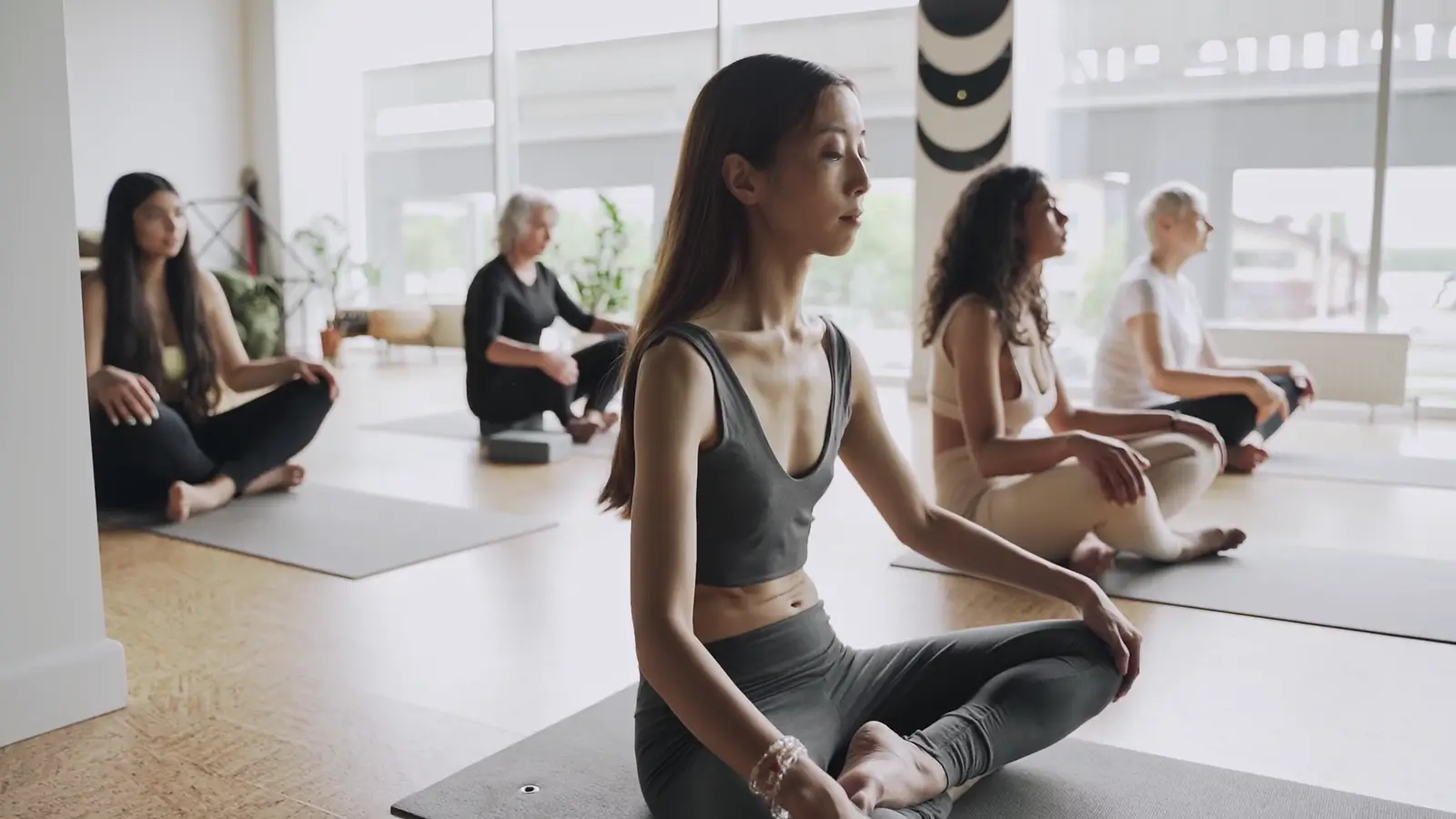 Yoga students practising together in a light-filled studio